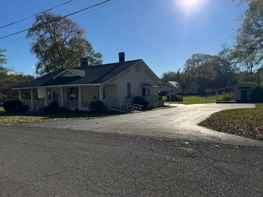 McGinnis house with a driveway and trees in the background